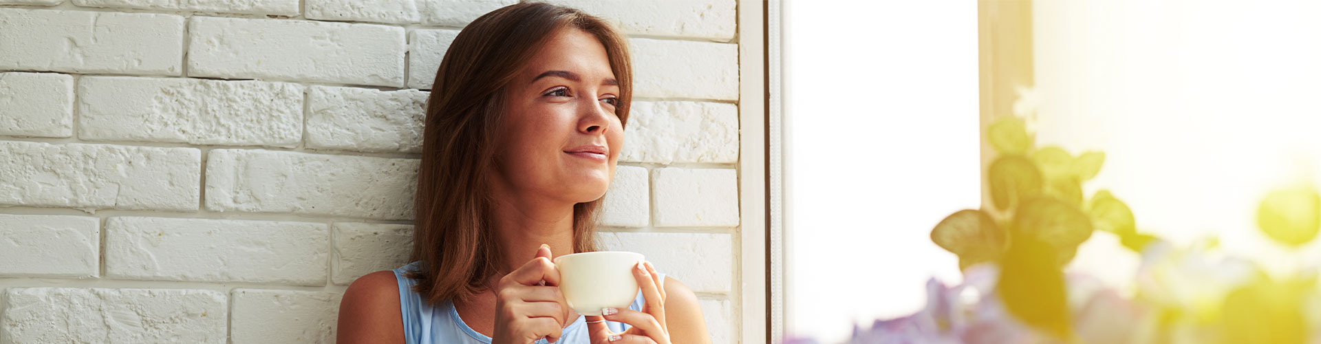 woman sipping tea by a  window